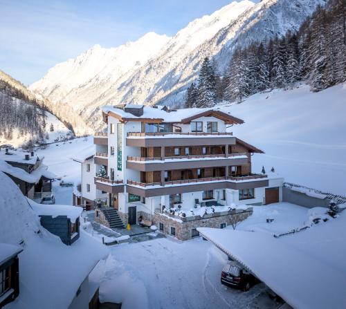 a building in the snow in front of a mountain at Hotel Garni Schönblick in Sölden