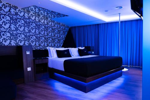 a bedroom with a large bed with blue lighting at Motel Avenue in Valongo