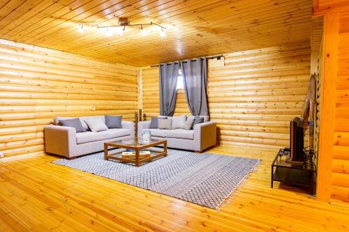 a living room with two couches and a coffee table at Chalet Styga Kalavrita in Kalavrita