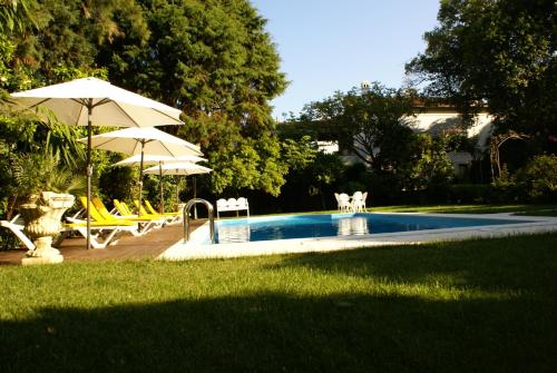 a swimming pool with umbrellas and chairs next to a yard at Quinta de São Lourenço in São Lourenço do Bairro