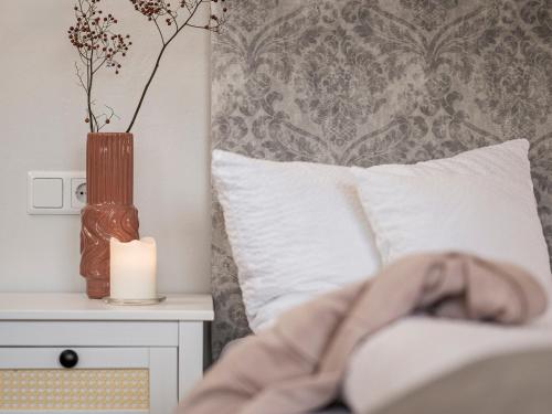 a bed with a candle and a vase on a table at Haus Grünberg in Finkenberg