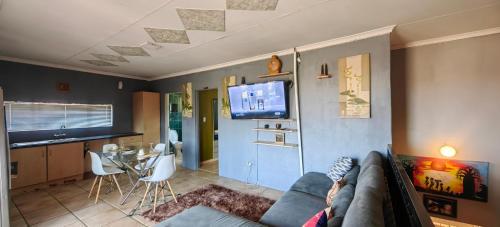 a living room with a couch and a flat screen tv at St Michael & The Queen in Johannesburg