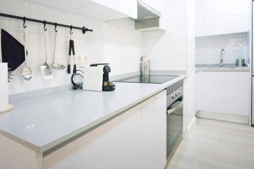Biała kuchnia z blatem i zlewem w obiekcie NEW AND COZY-STUDIO-CHUECA w Madrycie