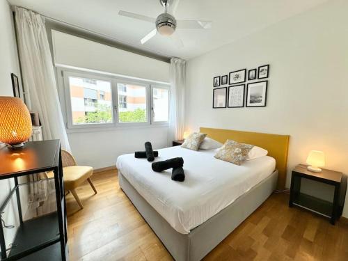 une chambre avec un lit, un bureau et une fenêtre dans l'établissement Cosy 2 pièces élégant proche gare et port Vauban, à Antibes