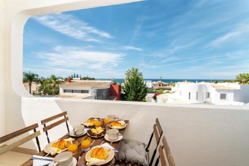 a table with food on a balcony with a view of the ocean at Host Wise - Bright Lovely Flat - Balcony in Guia