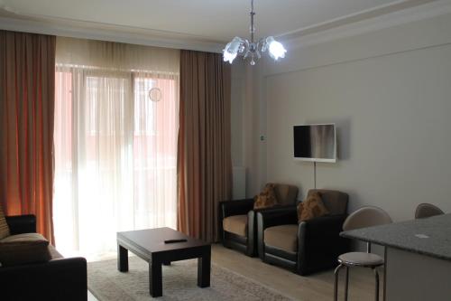 a living room with a couch and a table and a tv at Almasa Suite Aparts in Termal