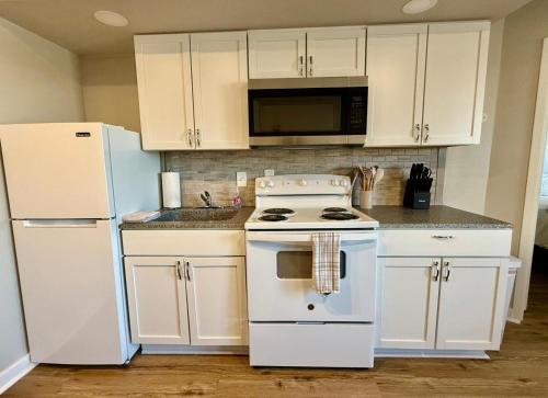 a kitchen with a white stove and a refrigerator at Aksarben View One Bedroom in Omaha