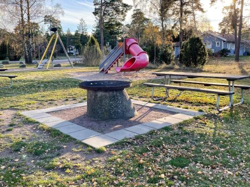 a park with a playground with a slide and benches at 7 person holiday home in Mönsterås in Mönsterås