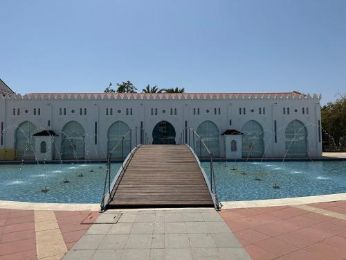 Un edificio con una pasarela de madera que conduce a una piscina. en The Port House, en Grao de Castellón