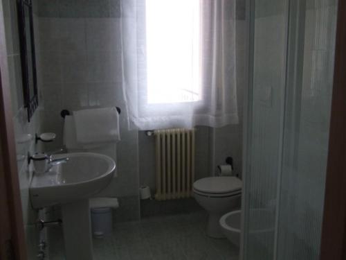 a bathroom with a sink and a toilet and a window at B&B Catullo in Sirmione