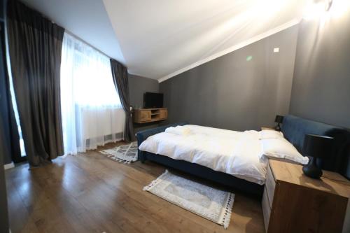 a bedroom with a bed and a large window at La Ancuța-n Bucovina in Gura Humorului