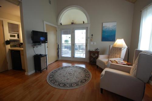 a living room with a couch and a tv at Shaker Mill Inn in West Stockbridge