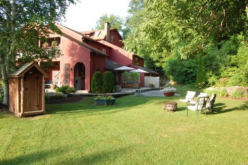 a house with a yard with chairs in the grass at Shaker Mill Inn in West Stockbridge