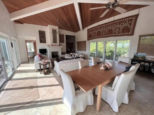 a dining room with a wooden table and white chairs at Wonderful Winding Bay in Tarpum Bay