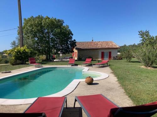 une piscine dans une cour avec des chaises et une maison dans l'établissement Le Chalet, à Sainte-Colombe