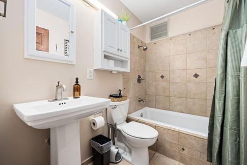 a bathroom with a sink and a toilet and a tub at Poolside Palisade - A Fun Family Retreat for 6 in Marquette Heights