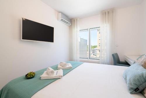 una camera da letto con un letto, una tv e una finestra di Host Wise - Stunning Trendy Flat w Balcony - Matosinhos a Matosinhos
