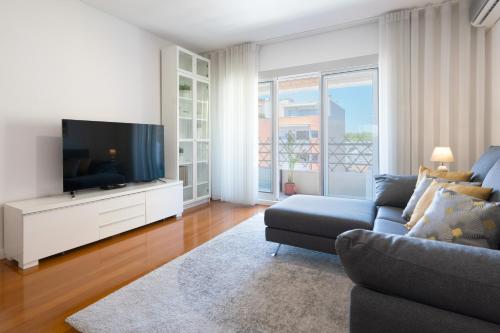 a living room with a couch and a flat screen tv at Host Wise - Stunning Trendy Flat w Balcony - Matosinhos in Matosinhos