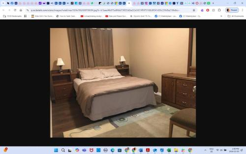 a bedroom with a bed with two dressers and two lamps at Room # 2 sleep 4 Arrangement in Edmonton
