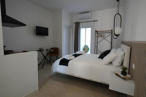 a white bedroom with a white bed and a table at B&B CasaLù in Sammichele di Bari