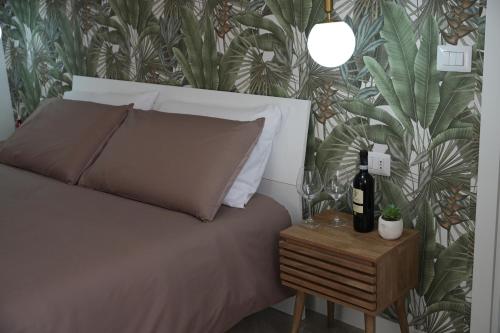 a bedroom with a bed and a table with a bottle of wine at B&B CasaLù in Sammichele di Bari