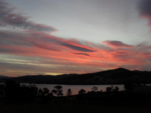 a sunset over a body of water with red clouds at Moon River in Gardners Bay