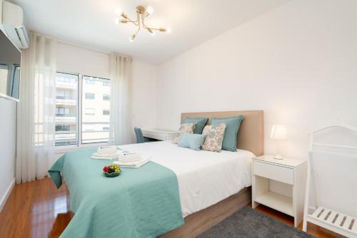 a white bedroom with a bed and a table at Host Wise - Stunning Trendy Flat w Balcony - Matosinhos in Matosinhos