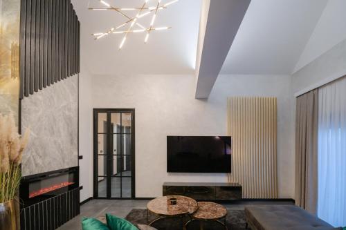a living room with a television and a table at UpArt Home & Spa in Ðakovo