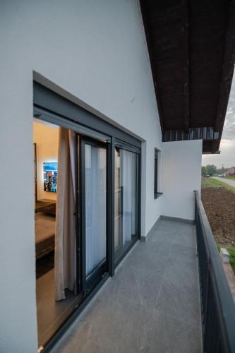 a house with large windows and a balcony at UpArt Home & Spa in Ðakovo