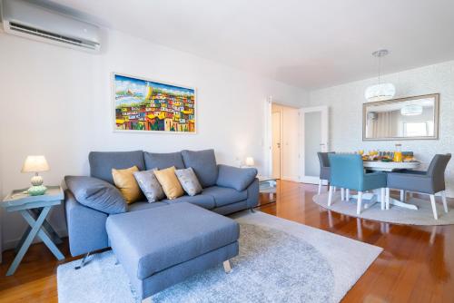 un soggiorno con un divano blu e un tavolo di Host Wise - Stunning Trendy Flat w Balcony - Matosinhos a Matosinhos