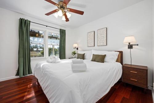 a bedroom with a large white bed with a ceiling fan at A Pop of Color - 3BD in the Heights w 3 King Beds in Peoria Heights