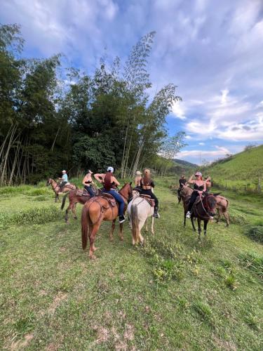 a group of people riding horses in a field at Finca Hotel Sawa in Maceo