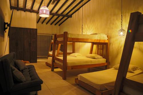 a room with two bunk beds and a couch at Finca Hotel Sawa in Maceo