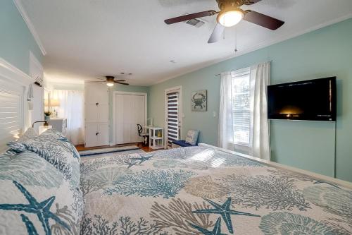 a bedroom with a bed and a ceiling fan at The Cozy Blue Cottage in Long Beach