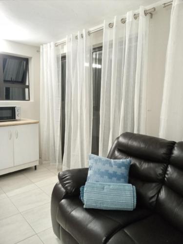 a black leather couch with a blue pillow in a living room at Knysna Nature's View in Knysna