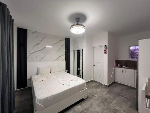 a bedroom with a white bed and a marble wall at Costa Love Hotel Aeropuerto in Punta Cana