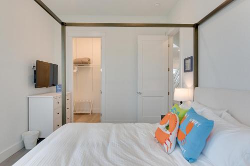 a bedroom with a white bed and a television at Walk to Ocean Home with Deck in Surfside Beach! in Surfside Beach