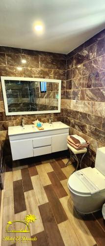 a bathroom with a toilet and a sink at Hotel El Dorado in La Romana