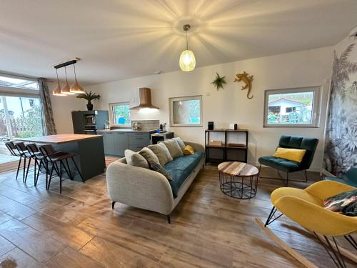 un salon avec un canapé et une cuisine dans l'établissement Gîte de plain-pied, à Les Abrets en Dauphine