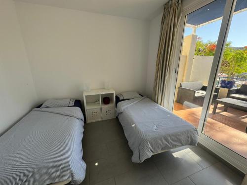Dos camas en una habitación con balcón. en MONTE GOLF - TERRACE - POOLS - OCEAN VIEW - BEACH - WIFI - QUIET Complex, en Playa del Cura
