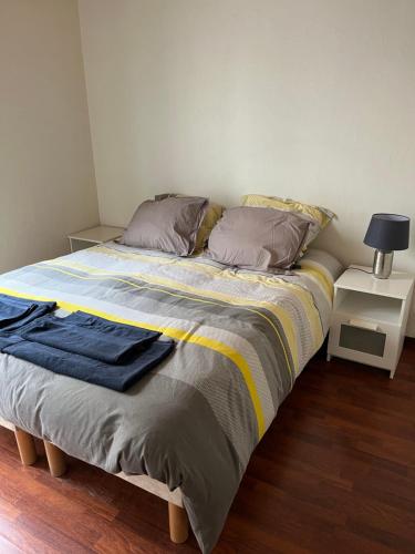 - un lit avec une couverture et des oreillers dans l'établissement Appartement à Levallois, à Levallois-Perret