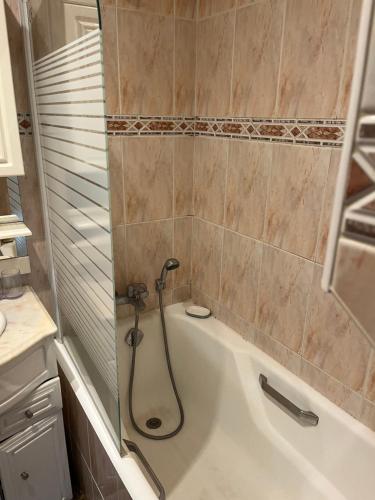 une salle de bain avec baignoire et douche dans l'établissement Appartement à Levallois, à Levallois-Perret