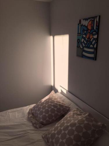 - un lit avec un oreiller et une peinture murale dans l'établissement Appartement vu sur mer Canet en Roussillon, à Canet