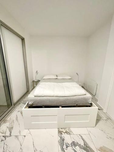 - une chambre blanche avec un lit dans une chambre blanche dans l'établissement Appartement T2 front de mer, vue panoramique, au Grau-du-Roi