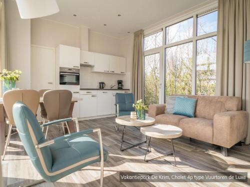 De CocksdorpにあるCozy Chalet Near North Seaのソファとテーブルのあるリビングルーム