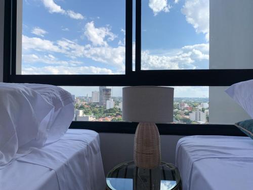 a bedroom with two beds and a large window at En piso 18. Excelente ubicación, Barrio Carmelitas in Asuncion