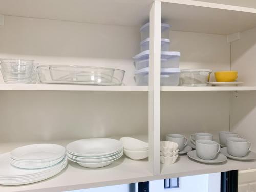 a white cabinet filled with plates and cups and bowls at En piso 18. Excelente ubicación, Barrio Carmelitas in Asuncion