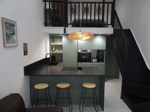 une cuisine avec un îlot avec deux tabourets et un comptoir dans l'établissement Loft Cosy Marseille, à Marseille