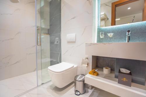 a bathroom with a toilet and a glass shower at Metropol Hotel in Ferizaj