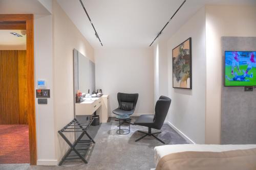 a bedroom with two chairs and a desk and a bed at Metropol Hotel in Ferizaj